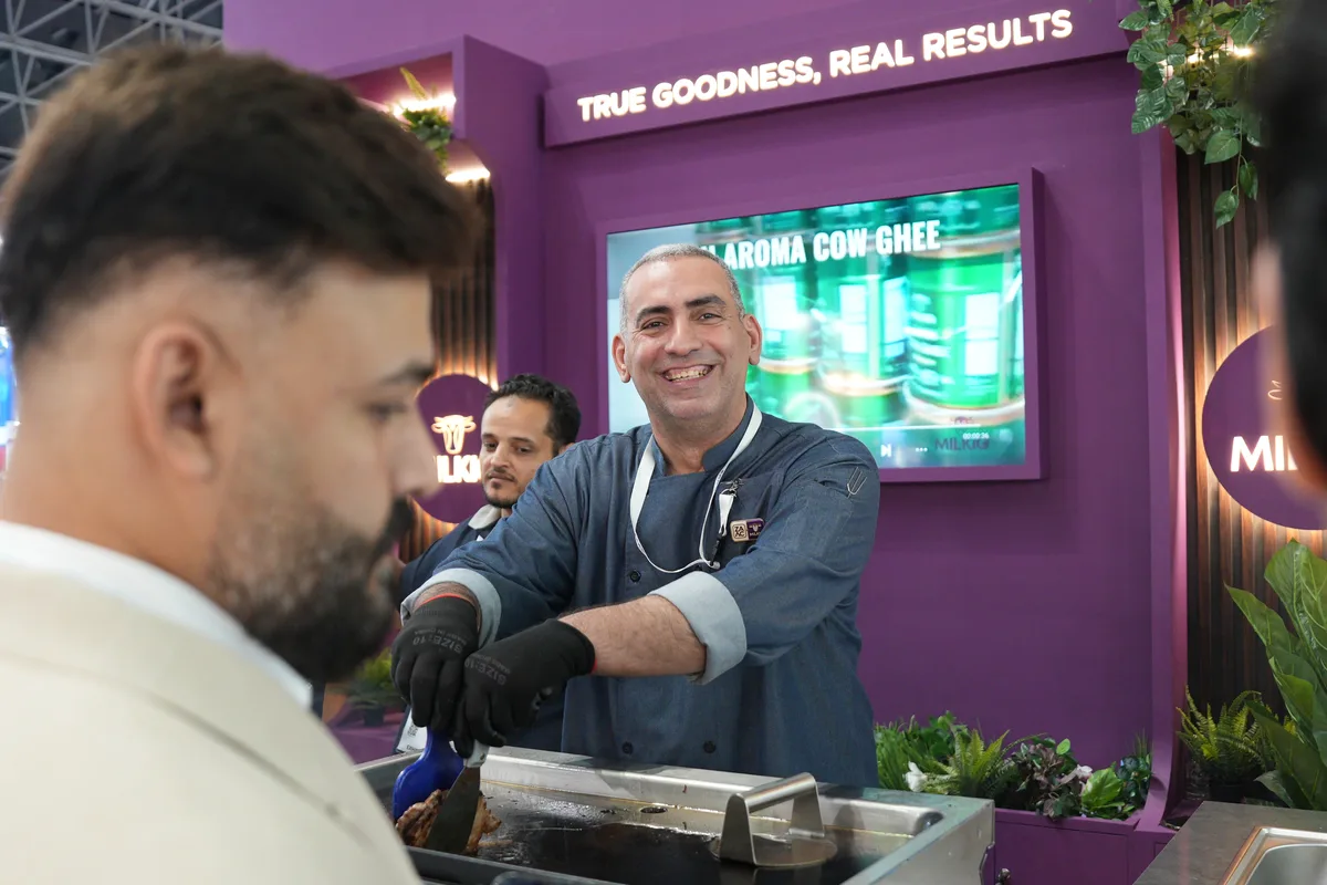 The head chef smiling as he cooks at the booth grill